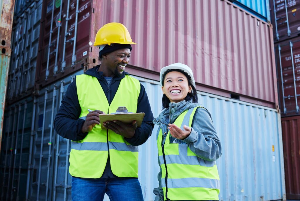 Warehouse, management and cargo stock with man and woman discuss checklist and laughing at factory